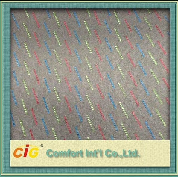 Strukturierter Stoff mit einem mehrfarbigen Zickzack-Muster und einem Logo von Comfort Intl Co., Ltd. in der unteren rechten Ecke.
