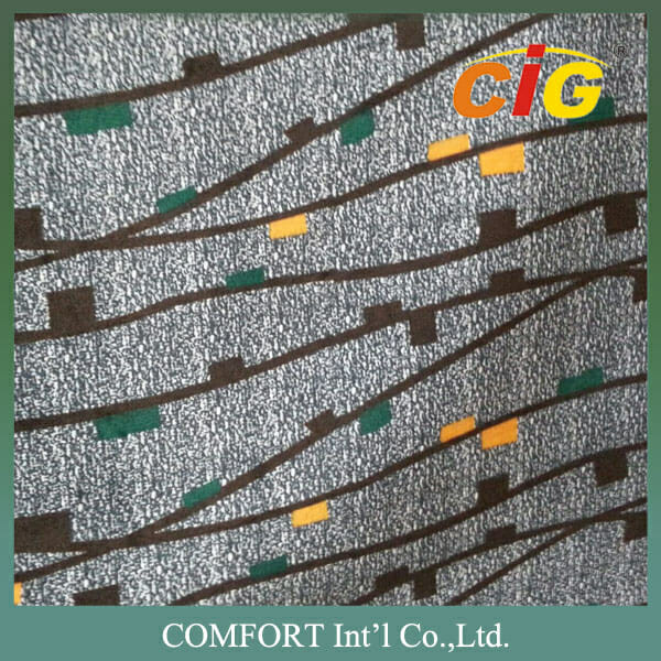 Texturovaná látka s diagonálními tmavě hnědými pruhy a rozptýlenými zelenými a oranžovými čtverečky s logem a názvem společnosti: comfort int'l co., ltd.