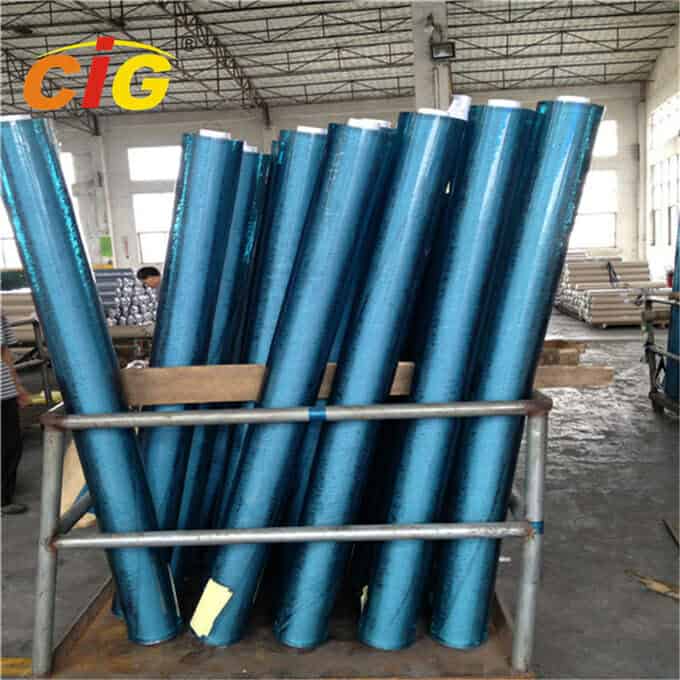 Velike plave pvc cijevi pohranjene okomito u policama unutar industrijskog skladišta.