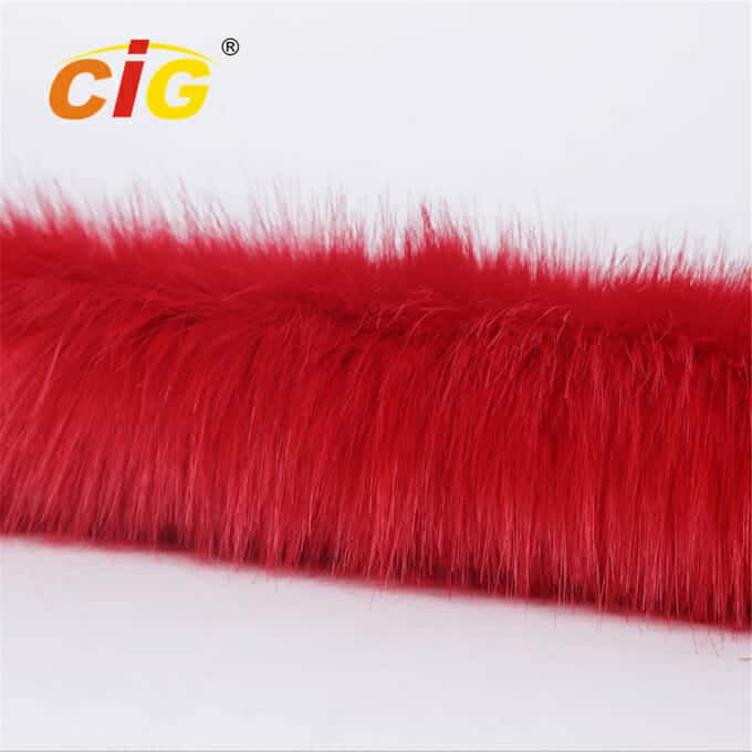 Image en gros plan d'une bande de tissu en fausse fourrure rouge vif et moelleux sur un fond blanc.