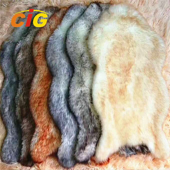 A collection of various colored fur pelts arranged in a row on a fluffy surface.