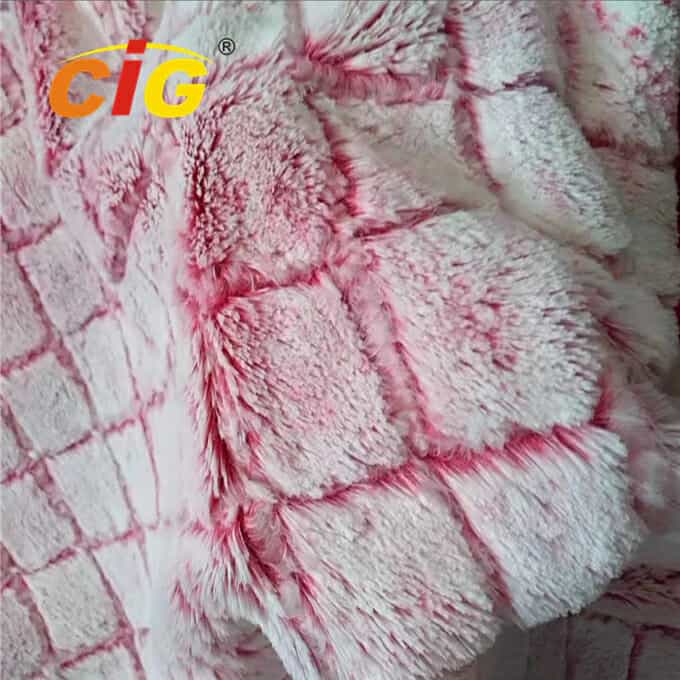 Tampilan jarak dekat dari kain bertekstur merah muda dan putih dengan tampilan mewah seperti bulu, menampilkan detail serat dan variasi warna.